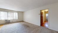 Located at 4426 Chowen Ave S in the Fulton neighborhood of Minneapolis, this two-bedroom, one-bathroom unit offers a practical and well-organized single-floor layout. The living area is finished with wall-to-wall carpet and features a large window that allows natural light to fill the space, complemented by baseboard heating along the perimeter walls. A classic paneled wood door leads from the living area into the hallway, where warm hardwood flooring begins and extends throughout the rest of the unit. The kitchen is efficiently designed in a U-shaped configuration, outfitted with oak cabinetry, dark granite-style countertops, and black appliances including a gas range, over-the-range microwave, and refrigerator, all set atop light hardwood floors. The primary bedroom offers a mirrored sliding closet and hardwood flooring, while the second bedroom also features hardwood floors, a ceiling fan, and a window with outdoor views. A third, smaller room with hardwood floors provides additional flexibility. The bathroom is clean and straightforward, featuring a fully tiled tub-shower surround in white, with a window for ventilation. Two hallways connect the rooms, creating a clear and functional flow throughout the unit.