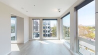 Located at 4116 NE Garfield Ave in Portland, Oregon, this single-floor unit showcases a contemporary design aesthetic defined by clean lines, neutral tones, and an abundance of natural light. The living area is a standout feature, boasting expansive floor-to-ceiling windows on two walls that frame elevated views of the surrounding neighborhood and tree canopy. Light wood-look flooring runs throughout, complementing the crisp white walls and ceilings to create a bright, airy atmosphere.

The kitchen is thoughtfully designed with warm wood-grain cabinetry extending to the ceiling for ample storage, light quartz countertops, a subway tile backsplash, and a full suite of stainless steel appliances including a gas range, over-the-range microwave, dishwasher, and refrigerator. A dedicated laundry area houses a stacked full-size washer and dryer unit, adding everyday convenience. The bathroom features a full soaking tub and shower combination with chrome fixtures and clean white surround. The overall layout, as revealed in the 3D model view, offers a well-organized floor plan with clearly defined living, kitchen, and private spaces, making efficient use of the available square footage.