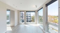 Located at 4116 NE Garfield Ave in Portland, Oregon, this single-floor unit showcases a contemporary design aesthetic defined by clean lines, neutral tones, and an abundance of natural light. The living area is a standout feature, boasting expansive floor-to-ceiling windows on two walls that frame elevated views of the surrounding neighborhood and tree canopy. Light wood-look flooring runs throughout, complementing the crisp white walls and ceilings to create a bright, airy atmosphere.

The kitchen is thoughtfully designed with warm wood-grain cabinetry extending to the ceiling for ample storage, light quartz countertops, a subway tile backsplash, and a full suite of stainless steel appliances including a gas range, over-the-range microwave, dishwasher, and refrigerator. A dedicated laundry area houses a stacked full-size washer and dryer unit, adding everyday convenience. The bathroom features a full soaking tub and shower combination with chrome fixtures and clean white surround. The overall layout, as revealed in the 3D model view, offers a well-organized floor plan with clearly defined living, kitchen, and private spaces, making efficient use of the available square footage.