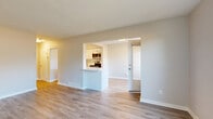 Located at 12 Auburndale Crt in Toronto's M9W neighbourhood, this three-bedroom, one-bathroom home spans three floors, offering generous and well-distributed living space. The main floor serves as the heart of the home, featuring an open-concept layout where the living room, dining room, and kitchen flow seamlessly together. The kitchen stands out with crisp white shaker-style cabinetry, a subway tile backsplash, stainless steel appliances including a dishwasher, range, and over-the-range microwave, and light wood-style flooring that extends throughout the main level. A breakfast bar connects the kitchen to the living and dining areas, enhancing the open feel. Large windows in the living room invite ample natural light and provide views of the outdoor surroundings. The upper floor houses the three bedrooms, including the primary bedroom, each finished with light laminate flooring and neutral-toned walls. The bathroom is finished in clean white tones with tile flooring and a full tub-shower combination. The lower level provides additional functional space, including a laundry area. Outside, the home features a private, fully fenced backyard with a lush lawn, wooden privacy fencing, and a gated entry — ideal for outdoor enjoyment. Wood-tread staircases with white risers connect all three levels cleanly and efficiently.