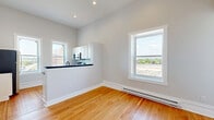 Located at 3 State St in Schenectady, NY, this one-bedroom, one-bathroom unit offers a thoughtfully arranged layout across a single floor. Warm hardwood flooring flows throughout the space, lending a cohesive and inviting character to every room.

The kitchen is a standout feature, outfitted with white shaker cabinetry, dark countertops, and a classic white subway tile backsplash. Stainless steel appliances — including a gas range, microwave, and refrigerator — complement the modern aesthetic, while a matte black faucet adds a contemporary accent. Two windows bring in generous natural light and offer views of the surrounding Schenectady streetscape.

The bedroom is a well-proportioned, quiet retreat with hardwood floors, light gray walls, and a window that frames outdoor views. Baseboard heating ensures year-round comfort, and a connecting door provides easy access to the rest of the unit.

The bathroom is finished with white subway tile surrounding a full tub-shower combination enclosed by a sleek glass sliding door with black trim. Classic black-and-white mosaic floor tile ties the design together for a clean, timeless look.

A hallway connects the rooms efficiently, completing a practical and well-designed layout suited for comfortable everyday living.