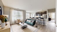 This well-appointed single-floor residence at 5284 Avery Rd in Columbus, Ohio offers a thoughtfully designed open-concept layout that seamlessly connects the living, dining, and kitchen areas. The living space is bathed in natural light through large windows with blinds and sheer curtains, and features light wood-style flooring and a bold patterned accent wall that adds visual character. The kitchen is outfitted with dark cabinetry, granite countertops, stainless steel appliances including a range, microwave, and refrigerator, and offers generous counter and storage space alongside a breakfast bar with seating. Multiple bedrooms provide comfortable retreats, each carpeted and filled with natural light from large windows. One bedroom features a striking dark accent wall, while another boasts dual windows and a ceiling fan. The bathrooms are clean and functional, with one offering a walk-in glass-enclosed shower with built-in shelving, and another featuring a full shower-tub combo. A spacious walk-in closet with built-in wire shelving accompanies one of the bathrooms, providing ample storage. The overall ambiance throughout the residence is contemporary and cohesive, with neutral tones, modern finishes, and an abundance of natural light creating a bright and welcoming atmosphere.