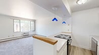 Located at 1191 High Ave in Oshkosh, Wisconsin, this 2-bedroom, 1-bathroom unit offers a practical and comfortable single-floor layout. The living room is the largest area of the home, featuring plush carpeted flooring, a large picture window that fills the space with natural light and provides views of the surrounding greenery, and baseboard heating along with a wall-mounted AC unit for year-round climate control. The clean, white walls throughout create a bright and neutral backdrop.

The primary bedroom is generously sized, outfitted with soft carpeting, a ceiling fan with integrated lighting, and a mirrored sliding-door closet that adds both storage and a sense of openness. The second bedroom also features carpeting, a ceiling fan, a window with natural light, and built-in wall shelving for added storage convenience. Both bedrooms are served by baseboard heating.

The bathroom includes wood-look vinyl flooring, a full tub and shower with neutral tile surround, and a vanity with storage. A connecting hallway links all rooms efficiently. The overall aesthetic is clean, simple, and functional, making this a well-organized unit well-suited for comfortable everyday living in a residential Oshkosh neighborhood.