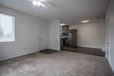 Located at 13128 Edgemont St in Moreno Valley, CA, this single-story unit offers a well-organized layout with a clear separation between living, dining, and sleeping areas. The flooring transitions between warm wood-look vinyl in the kitchen and high-traffic zones and plush carpeting throughout the living room and bedrooms, creating a comfortable and practical environment.

The kitchen is a standout feature, designed in a U-shaped configuration with warm-toned wood cabinetry extending to the upper walls, granite-style countertops, and a full suite of stainless steel appliances including a dishwasher, range, over-the-range microwave, and refrigerator. A window above the sink allows natural light to fill the space.

The living room is generously proportioned, topped with a ceiling fan, and opens directly onto a private balcony through sliding glass doors with vertical blinds—providing outdoor access and neighborhood views. An adjacent area connects seamlessly to the kitchen, enhancing the open feel of the main living space.

Bedrooms are carpeted and well-lit, with windows fitted with blinds and ceiling fans for comfort. The bathroom features wood-look vinyl flooring, a single-sink vanity with warm wood cabinetry, and a large mirror. A dedicated in-unit laundry area with washer and dryer hookups adds everyday convenience.