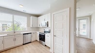 Located at 4103 Rogers Rd in San Antonio, TX, this single-story, one-bedroom, one-bathroom home offers a well-designed layout with a clean, modern aesthetic throughout. Light-toned walls, white trim, and a consistent use of light wood-look flooring in the main living areas create a bright and cohesive interior.

The kitchen is a standout feature, equipped with crisp white cabinetry accented by matte black hardware, a herringbone tile backsplash, and a full suite of stainless steel appliances including a refrigerator, electric range, over-the-range microwave, and dishwasher. A window above the sink allows natural light to fill the space.

The living room features luxury vinyl plank flooring, a ceiling fan, and multiple windows fitted with blinds that invite natural light while maintaining privacy. The bedroom is carpeted for comfort, includes a ceiling fan, and connects to a spacious walk-in closet outfitted with dual hanging rods and built-in shelving.

The bathroom is finished with a white vanity, framed mirror, and a tub-shower combination with tiled surround. A dedicated laundry area accommodates a full-size washer and dryer. This home offers a practical and polished living environment suited for comfortable everyday living.