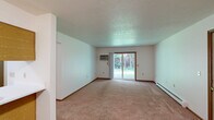 Located at 1752 Raleigh Ave in Lapeer, Michigan, this single-floor, two-bedroom, one-bathroom home offers a functional and well-organized layout. The open-concept living and dining area is carpeted throughout and features a sliding glass door that leads to a private patio, offering peaceful views of the surrounding greenery. A wall-mounted AC unit and baseboard heating provide year-round comfort in the main living space.

The kitchen is defined by a pass-through counter with wood-paneled detailing, connecting it seamlessly to the dining area. It is equipped with a refrigerator, electric range, and overhead ventilation. Three closets throughout the home provide ample storage.

The primary bedroom is generously sized, featuring two windows that invite natural light and views of the lush outdoor landscape, along with baseboard heating and carpeted floors. The second bedroom also includes a window with wooded views, carpeting, and two closets with warm wood-toned doors, offering plenty of storage.

The full bathroom features tile flooring, a single vanity with a large mirror, a bathtub/shower combo, and baseboard heating. A dedicated laundry area and a connecting hallway complete the thoughtful floor plan. The textured ceilings add a classic touch throughout the home.