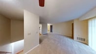 This single-floor residential unit offers a well-organized layout designed for comfortable everyday living. The generously sized living room is carpeted and bathed in natural light through large sliding glass doors that open to an outdoor balcony, framing views of surrounding greenery. A ceiling fan adds to the room's functionality, while a built-in closet with warm wood-toned bifold doors provides convenient storage.

The kitchen features white cabinetry with oak wood trim, granite-look laminate countertops, and a full suite of white appliances including an electric range with overhead ventilation. The layout maximizes counter and cabinet space efficiently.

The bedroom is a quiet, carpeted retreat with a window that allows natural light to filter in. It includes access to a walk-in closet with built-in shelving, offering ample storage. A second closet with bifold doors is also present near the living area.

The bathroom includes a full tub and shower combination with chrome fixtures and a curtain rod, complemented by wood-look vinyl flooring. A separate laundry area is equipped with washer hookups, a grab bar for accessibility, and matching vinyl flooring. Neutral warm tones and clean finishes throughout create a cohesive, move-in-ready atmosphere.