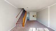 Located at 204 Chambers Cove Drive in Macon, Georgia, this two-story residence offers a practical and comfortable layout across two floors. The main level features a carpeted living area filled with natural light streaming through large windows, and a staircase with warm wood banisters leading to the upper floor. The kitchen is efficiently designed with wood cabinetry, laminate countertops, a full appliance suite including an electric range and refrigerator, and a window that brings in natural light. Crown molding throughout the home adds a classic finishing touch. Upstairs, two carpeted bedrooms provide comfortable retreats, each featuring windows with blinds that allow for natural light and privacy. The spacious primary bedroom includes closet storage with built-in rods. Both bathrooms are functional and well-appointed, with one featuring a wood-toned vanity with ample cabinet storage, a large mirror, and hardwood-style flooring. A hallway connects the upper-level rooms, and a dedicated closet adds to the storage options. Neutral wall tones and consistent trim work create a cohesive, move-in-ready aesthetic throughout the home.