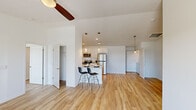 Located at 8495 Hoke Rd in Clayton, Ohio, this single-floor residence offers a clean, modern aesthetic throughout its open-concept layout. The main living area is expansive and airy, featuring warm light hardwood flooring, vaulted ceilings, and ceiling fans that enhance the sense of openness. A central kitchen island with a granite countertop and seating for two serves as the focal point of the living and dining space, ideal for casual dining and entertaining.

The kitchen is well-equipped with white shaker cabinetry, granite countertops, stainless steel appliances including a refrigerator, range, microwave, and dishwasher, as well as a stainless steel sink. Pendant lighting above the island adds a refined touch.

The bedrooms are generously sized, with plush carpeting, ceiling fans, and large windows fitted with blinds that allow ample natural light and views of the surrounding neighborhood. One bedroom features a walk-in closet with wire shelving on multiple walls, providing substantial storage capacity.

The bathroom includes a full-sized soaking tub and shower combination with clean white surround. Throughout the home, the neutral white walls and bright finishes create a cohesive, contemporary atmosphere that is both functional and inviting.