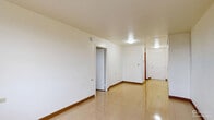 Located at 135 Main St in Poughkeepsie, NY, this two-bedroom, one-bathroom unit is laid out on a single floor with a practical and functional design. The interior features light-toned tile flooring throughout, white walls, and wood baseboard trim that runs consistently across all rooms.

The galley-style kitchen is lined with warm honey-toned wood cabinetry on both upper and lower levels, providing ample storage. It includes a double sink with a laminate countertop, a white electric range, and a full-size refrigerator, making efficient use of its compact, corridor layout.

The primary bedroom is generously sized, offering a comfortable living area with a window that brings in natural light and views of the surrounding neighborhood. Baseboard heating units are present for climate control. The second bedroom is more compact, also featuring a window with an exterior view and baseboard heating.

The shared bathroom is accessible from the primary bedroom area and features cream-toned wall tiles, a shower-tub combination with grab bars, a pedestal sink, and a wall-mounted mirror. A closet adjacent to the bathroom provides additional storage.

The open living and hallway area connects all rooms seamlessly, offering a clear and navigable floor plan. Natural light filters in through the unit's windows, contributing to a bright and livable atmosphere throughout.