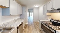 Located at 2827 S Emporia St in Wichita, Kansas, this single-floor, 2-bedroom, 2-bathroom unit offers a practical and well-appointed layout. The galley-style kitchen is a standout feature, showcasing gray shaker cabinets, granite-style countertops, stainless steel appliances including a refrigerator, electric range, and dishwasher, and wood-look vinyl plank flooring that extends into the hallway. A window with white blinds brings in natural light, keeping the kitchen bright and functional.

Both bedrooms are comfortably sized, finished with wall-to-wall carpet and ceiling fans with light fixtures. The primary bedroom includes a closet with bi-fold panel doors, offering convenient storage. The second bedroom also features a window with blinds, allowing for natural light and outdoor views. The neutral, warm-toned walls throughout contribute to a clean and cohesive aesthetic.

The two bathrooms each include a full tub-shower combo with white surround panels and gray cabinetry above. The overall design of the unit is straightforward and functional, with consistent finishes throughout that create a tidy, move-in-ready environment suitable for everyday living.