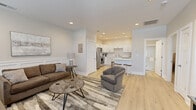 Located at 6209 Boston Way in Evansville, Indiana, this thoughtfully designed 2-bedroom, 1-bathroom single-story home offers a clean, modern aesthetic throughout. Light wood-tone flooring flows seamlessly across the entire living space, tying together a cohesive and contemporary feel.

The open-concept living and kitchen area serves as the heart of the home. The living room is bright and welcoming, featuring large windows with white blinds that allow ample natural light, recessed lighting, wainscoting wall detailing, and a front entry door with transom window. The kitchen is well-appointed with white shaker-style cabinetry, light quartz countertops, a white subway tile backsplash, and a full suite of stainless steel appliances including a refrigerator, range, over-the-range microwave, and dishwasher. A breakfast bar with seating provides a casual dining option.

The primary bedroom is a comfortable retreat, featuring a ceiling fan, natural light from a window with blinds, and room-darkening roller shades. The second bedroom offers similar finishes with a clean, neutral palette.

The bathroom showcases a sleek, fully tiled walk-in shower with a glass sliding door and chrome fixtures, maintaining the home's modern and polished design throughout.