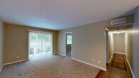 Located at 1246 Mooty Bridge Rd in LaGrange, Georgia, this single-floor 2-bedroom, 2-bathroom residence offers a functional and comfortable layout across a thoughtfully arranged floor plan. Warm beige walls and textured ceilings carry throughout the home, creating a cohesive and inviting atmosphere.

The living room is a welcoming space featuring plush carpeting and a sliding glass door fitted with vertical blinds that opens onto a private balcony with views of lush greenery. Adjacent to the living room, the dining area features hardwood flooring and an elegant chandelier overhead, ideal for everyday meals or entertaining.

The galley-style kitchen is efficiently designed with rich wood cabinetry, a tile backsplash, granite-style countertops, and full appliances including a range and refrigerator. Hardwood flooring continues through this area, adding warmth and durability.

Both bedrooms are carpeted and filled with natural light from large windows overlooking the surrounding greenery. The primary bedroom offers a generous footprint along with dedicated closet space. Each of the two bathrooms includes a full tub and shower combination with clean white tile surrounds and wood-toned vanity cabinetry. Additional closets throughout provide ample storage for everyday living.