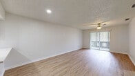 Located at 2630 NE 52nd Ct in Silver Springs, Florida, this single-story home presents a clean, updated interior with a cohesive and bright aesthetic throughout. Light wood-style flooring runs continuously across the living spaces, bedrooms, and bathrooms, creating a warm and unified look.

The expansive main living area is open and airy, featuring a ceiling fan and large sliding glass doors dressed with vertical blinds that invite natural light and provide access to the outdoors. A pass-through window connects the living area to the kitchen, enhancing the open flow between spaces.

The kitchen is thoughtfully designed with crisp white shaker-style cabinetry, white quartz countertops, a stainless steel sink, and a full suite of stainless steel appliances including a refrigerator, range, over-the-range microwave, and dishwasher. Recessed lighting illuminates the space efficiently.

The bedrooms are well-proportioned, each featuring ceiling fans, neutral walls, and windows with blinds that frame views of the surrounding greenery. The bathrooms maintain the home's clean aesthetic with white vanities topped with quartz countertops, undermount sinks with brushed nickel fixtures, tiled tub-shower combinations, and textured ceilings. The overall ambiance is fresh, neutral, and move-in ready.