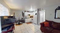 Located at 1619 Lake Ave in Tallahassee, Florida, this single-floor home offers a functional and efficiently laid-out living space. The open-concept main area seamlessly connects the kitchen and living room, creating a cohesive and practical environment. The kitchen features white cabinetry, a white appliance suite including a range and refrigerator, a granite-style countertop with sink, and a built-in microwave. A cozy dining nook sits adjacent to the kitchen, providing a convenient spot for casual meals. The living room is a welcoming space highlighted by light tile flooring, wall shelving for display, a decorative ornate mirror, and a front-facing window that allows natural light to fill the room. The bedroom is a restful retreat featuring light tile flooring, windows with drapes that invite natural light, a dedicated vanity area, and wall-mounted artwork that adds character. A bathroom with a shower-tub combination, vanity, and tile surfaces completes the layout. Consistent light tile flooring flows throughout the home, lending a clean, unified aesthetic. This home offers a practical and personalized living environment in a single-story setting.