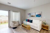 Located on Garfield Road in Clinton Township, Michigan, this single-floor, 2-bedroom, 1-bathroom residence offers a thoughtfully designed layout with a clean, contemporary aesthetic throughout. The living room welcomes with warm neutral tones, light wood-style flooring, large windows dressed in sheer curtains, and a sliding door that opens to a private patio, filling the space with natural light. The open-concept kitchen and dining area is outfitted with stainless steel appliances, a dishwasher, sleek taupe cabinetry, white quartz countertops, recessed lighting, and a peninsula that accommodates casual dining. The primary bedroom is generously sized, while the second bedroom offers versatile space suitable as a guest room or home office. Both rooms feature plush carpeting, ample natural light, and closet storage. The bathroom provides a clean, modern finish with a wood-toned vanity, illuminated mirror, tile flooring, and a dedicated walk-in shower. Additional highlights include three closets for abundant storage, a hallway connecting all rooms, and an in-unit laundry area for added convenience. The overall ambiance is bright, neutral, and move-in ready.