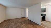 Located at 1706 22nd Way NE in Auburn, Washington, this one-bedroom, one-bathroom unit offers a practical and well-organized single-floor layout. The living room is generously sized, featuring durable wood-style flooring, neutral wall tones, textured ceilings, and dual windows that allow natural light to fill the space. A baseboard heating unit ensures year-round comfort. The combined kitchen and dining area is efficiently designed with dark cabinetry, white countertops, a stainless steel sink, and black appliances including an electric range. A ceiling fan with light fixture serves the dining space, which also features wood-style flooring. The bedroom is a comfortable retreat finished with plush carpeting, a closet, and sliding glass doors that open to a private balcony overlooking a green outdoor area, bringing in abundant natural light. An additional closet in the hallway provides extra storage. The bathroom includes a full tub and shower combination with clean white finishes and chrome fixtures. An in-unit laundry area adds everyday convenience. Overall, the space presents a clean, functional, and bright atmosphere suited for comfortable everyday living.