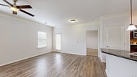 Located at 10505 W 134th St in Overland Park, Kansas, this two-story residence offers two bedrooms and two full bathrooms across a well-appointed layout. The main living level features an open-concept kitchen and living area with rich hardwood-style flooring, crown molding, and a ceiling fan that enhance the bright, airy atmosphere. The kitchen is outfitted with dark granite countertops, rich espresso cabinetry, a peninsula with a built-in sink, pendant lighting, and stainless steel appliances, with direct sightlines into the laundry area for added convenience. A private balcony off the main level provides pleasant views of the landscaped community exterior. The primary bedroom is a spacious retreat with hardwood-style flooring, crown molding, a ceiling fan, and multiple windows that invite natural light. The second bedroom features plush carpet and a ceiling fan, offering a comfortable and cozy space. Both bathrooms are well-appointed, with one featuring a tiled tub-surround, wood-look flooring, and a dark-toned vanity. Generous walk-in closets with wire shelving systems provide ample storage. The dedicated in-unit laundry area accommodates a full-size washer and dryer, adding everyday practicality to this thoughtfully designed home.