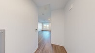 Located along I-90 E in Boston, MA, this thoughtfully designed studio offers a clean, modern aesthetic that maximizes every square foot of its single-floor layout. The open living area features warm wood-tone flooring and crisp white walls, creating a bright and welcoming atmosphere. A window allows natural light to flood the space while offering views of the surrounding Boston neighborhood.

The kitchen is a standout feature, outfitted with a full suite of stainless steel appliances — including a refrigerator, electric range, built-in microwave, and dishwasher. Cabinetry combines white lower units with natural wood-toned upper cabinets, complemented by a white subway tile backsplash and under-cabinet lighting that adds a refined touch. The layout is efficient yet stylish, providing ample storage and counter space.

The bathroom carries the same modern sensibility, with large-format light tile flooring, a sleek glass-paneled shower enclosure, and matte black hardware accents including a towel bar and toilet paper holder — lending a contemporary, upscale feel.

Throughout the unit, recessed lighting, a wall-mounted thermostat, and a mini-split HVAC unit ensure year-round comfort. This studio is a well-appointed and functional urban living space in the heart of Boston.