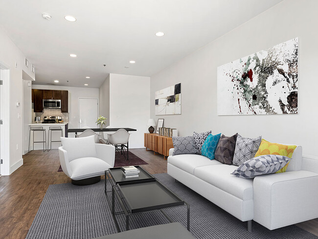 Hardwood floored living room with can lights and view of kitchen. - Bonita Terrace