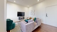 Located in the heart of downtown Tulsa, this 2-bedroom, 2-bathroom residence offers a thoughtfully designed layout with modern finishes and striking city skyline views. Rich hardwood flooring flows throughout the open living areas, anchoring a bright and airy aesthetic defined by crisp white walls and recessed lighting.

The combined kitchen and living area serves as the central hub of the home. The kitchen features white shaker cabinetry, dark lower cabinets, quartz countertops, subway tile backsplash, and a full suite of stainless steel appliances. A kitchen island with bar seating and pendant lighting adds both functionality and style. The living room offers generous space with large windows framing panoramic views of the Tulsa skyline.

Both bedrooms are well-proportioned, each with hardwood floors, recessed lighting, and large windows that flood the rooms with natural light and commanding downtown views. The primary bedroom includes a dedicated closet for added storage.

The two bathrooms are finished with large-format dark marble-style tile flooring, white vanities with quartz countertops, and glass-enclosed showers, delivering a clean, upscale feel. The overall design balances contemporary urban living with functional comfort, making this a well-appointed residence in a prime Tulsa location.
