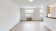Located at 5 Stag Hill Drive in Toronto's east end, this well-appointed 1-bedroom, 1-bathroom unit offers a clean, modern aesthetic across a thoughtfully laid-out single floor. Light hardwood flooring runs throughout, complementing the bright white walls and creating a cohesive, airy atmosphere.

The open-concept living room is generously sized, featuring large windows with views of surrounding trees and classic cast-iron radiators that add a charming architectural detail. Natural light fills the space throughout the day. The kitchen is designed in a sleek galley style, outfitted with cream cabinetry, dark countertops, stainless steel appliances including a built-in oven, microwave, refrigerator, and dishwasher, plus a window that overlooks the treetops.

The spacious primary bedroom offers ample room, a large sliding-door closet, a radiator for heating, and a window with natural views, creating a calm and comfortable retreat. The bathroom is finished with grey tile surrounds, a soaking tub with overhead shower, a dark vanity with integrated sink, and a mirrored medicine cabinet. A hallway connects all areas efficiently, completing this practical and well-finished unit.
