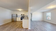 Located on Nava Ct in Carlisle, PA, this well-appointed 2-bedroom, 2-bathroom single-floor residence offers a clean, modern aesthetic throughout. The open-concept layout seamlessly connects the kitchen and living area, creating a bright and functional shared space. The kitchen is outfitted with white shaker-style cabinetry, granite-look countertops, a peninsula with sink, and a full suite of stainless steel appliances including a refrigerator, range, microwave, and dishwasher. Wood-style luxury vinyl plank flooring runs through the main living areas, providing a cohesive and easy-to-maintain surface. The spacious living room benefits from multiple windows that allow natural light to fill the room, with views of the surrounding neighborhood. Both bedrooms are carpeted for comfort, with the primary bedroom featuring direct access to its own bathroom and a dedicated walk-in closet with full rod storage. The second bedroom is also generously sized with a large window. Both bathrooms include tub-shower combinations, wood-look flooring, and white vanity cabinetry. A second closet provides additional storage. The residence presents a fresh, move-in-ready interior with a neutral color palette throughout.
