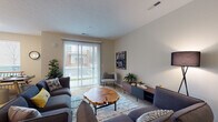 Located at 291 Graceland Blvd in Columbus, Ohio, this two-floor residence offers a thoughtfully designed layout with contemporary finishes throughout. The open-concept living area on the main floor is bright and welcoming, featuring sliding glass doors with vertical blinds that invite natural light and provide direct outdoor access. A second living or flex space on the upper floor offers additional room for relaxing or entertaining, with a staircase connecting both levels seamlessly.

The kitchen is a standout feature, equipped with dark espresso cabinetry, granite countertops, stainless steel appliances including a refrigerator, microwave, and electric range, and a center island with a sink and pendant lighting overhead. Track lighting and hardwood-style flooring complete the modern aesthetic. A dedicated in-unit laundry closet with a washer and dryer is conveniently positioned adjacent to the kitchen.

The bedrooms are carpeted and filled with natural light from large windows. The primary bedroom includes an en-suite bathroom featuring a double-sink vanity with granite countertops, dark cabinetry, hardwood-style flooring, and access to a spacious walk-in closet. A second full bathroom offers a tub-shower combination, single vanity, and hardwood-style flooring. Together, these spaces deliver a comfortable, functional, and stylish home.