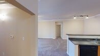 This single-floor residence offers a thoughtfully designed layout that balances comfort and functionality. The entry foyer welcomes you with warm-toned tile flooring and a solid paneled front door, setting the tone for the rest of the home. The open-concept living area features plush wall-to-wall carpeting, crown molding, and track lighting, seamlessly connecting to the kitchen. Sliding glass doors lead to a private balcony, providing natural light and outdoor views, complemented by a ceiling fan overhead.

The kitchen is well-equipped with warm wood cabinetry, dark countertops, tile flooring, and black appliances including an electric range, microwave, and sink — all arranged in a convenient U-shaped layout with a breakfast bar peninsula.

The bedrooms are carpeted and generously sized, each featuring vertical blinds over large windows that allow ample natural light, with ceiling fans providing year-round comfort. The two full bathrooms are finished with stone-look tile flooring, warm wood vanities, and tub-shower combinations with white tile surrounds. One bathroom includes a well-lit vanity mirror and additional storage. Together, these spaces create a cohesive and comfortable living environment.