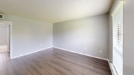Located at 459 Apartment Court Dr in Baton Rouge, Louisiana, this one-bedroom, one-bathroom unit offers a practical and well-organized single-floor layout. The living room greets residents at the entry with rich wood-look flooring, neutral gray walls, a textured ceiling, and a window fitted with blinds that allows natural light to filter in, creating a bright and welcoming atmosphere.

The galley-style kitchen is efficiently designed with white cabinetry lining both sides, light-toned countertops, a stainless steel sink, and pendant track lighting overhead. A black refrigerator and additional appliances provide functional cooking accommodations, while the wood-look flooring continues seamlessly from the main living areas.

The generously sized bedroom features plush carpeting, a ceiling fan with light fixture, soft gray walls, and a window overlooking the exterior, offering both comfort and natural light. The room also includes closet access, adding to its practicality.

The bathroom is equipped with a full tub-and-shower combination surrounded by beige tile, a toilet, and a vanity with a light stone-finish countertop and wood-look flooring. A hallway connects the rooms, contributing to the unit's cohesive and functional flow throughout.