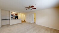 Located at 359 N West St in Indianapolis, Indiana, this single-floor, 2-bedroom, 2-bathroom residence offers a well-organized and comfortable layout. The open-concept living and kitchen area serves as the heart of the home, where plush carpeting and a ceiling fan create a relaxed atmosphere. The kitchen is equipped with rich dark wood cabinetry, granite countertops, a large peninsula with a double-basin sink, pendant lighting, and black appliances including a refrigerator, range, and microwave. The peninsula flows seamlessly into the living space, making it ideal for everyday living and entertaining.

The primary bedroom is a generously sized retreat, featuring soft carpeting, a ceiling fan, and a spacious walk-in closet with wire shelving systems that maximize storage. The second bedroom is carpeted as well and benefits from natural light through a window with blinds. Both bathrooms feature rich wood-toned cabinetry and durable wood-look flooring. One bathroom includes a corner glass-enclosed shower stall and a tall storage cabinet.

Additional highlights include three closets throughout the unit, a dedicated laundry area, and a utility room. The neutral color palette and consistent finishes throughout lend the space a cohesive and move-in-ready appeal.