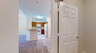 Located at 8201 Claire Ann Dr in Orlando, FL, this one-bedroom, one-bathroom single-floor residence offers a functional and well-organized layout. The kitchen is equipped with warm honey-toned wood cabinetry, white appliances including a range, built-in microwave, and refrigerator, and features light tile flooring. A breakfast bar peninsula provides a seamless transition into the adjacent living areas, both of which are finished with plush wall-to-wall carpeting and neutral beige tones that create a calm, cohesive atmosphere. The bedroom is a comfortable, well-proportioned space with soft carpet, a ceiling fan, and a window fitted with blinds that allows natural light to fill the room. The full bathroom includes a tiled shower-tub combination, a wood-vanity with countertop, and tile flooring. A dedicated laundry room comes equipped with washer and dryer hookups—both electric and gas connections—as well as overhead wire shelving for added storage. A separate closet provides additional organizational space. Throughout the unit, clean white trim and soft neutral wall colors contribute to a bright, move-in-ready environment suited for everyday living.