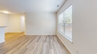 Located at 1475 Wilton Farm Road in Charlottesville, Virginia, this two-bedroom, one-bathroom single-floor residence offers a practical and well-organized layout. The entrance opens into a hallway that connects the main living areas, maintaining a clear and efficient flow throughout the unit. The living room is a bright, open space featuring light-toned luxury vinyl plank flooring, a textured ceiling, and a large window that allows natural light to fill the room. An adjacent dining area provides a dedicated space for meals, while the galley-style kitchen is outfitted with warm wood cabinetry, granite-style countertops, a stainless sink, and black appliances including a refrigerator, range, and dishwasher. Both bedrooms feature plush carpeting, neutral walls, and windows with outdoor views. The primary bedroom offers a comfortable footprint with ample room for furnishings. Three closets provide generous storage throughout the unit. The full bathroom includes a tub-shower combination and continues the LVP flooring found in the common areas. A dedicated laundry room comes equipped with washer and dryer hookups and overhead wire shelving, adding to the unit's practical amenities. A utility room completes the layout.