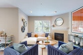 Located at 4 Liberty Ln in South Portland, Maine, this well-appointed 2-bedroom, 2-bathroom single-floor residence offers a thoughtfully designed layout with warm, contemporary finishes throughout. Light hardwood flooring flows seamlessly across the entire home, creating a cohesive and inviting atmosphere.

The open-concept living area is anchored by a classic fireplace and large windows that flood the room with natural light and views of surrounding greenery. The kitchen features modern stainless steel appliances including a gas range, sleek wood-toned cabinetry, under-cabinet lighting, and clean white countertops. A built-in desk nook provides a convenient workspace. The dining area connects directly to an outdoor patio via sliding glass doors, bringing in additional natural light and outdoor views.

Both bedrooms are generously proportioned, each featuring windows with lush tree views, ceiling fans, and warm neutral tones. The primary bedroom includes a dedicated walk-in closet with built-in shelving for ample storage. The bathrooms are well-appointed, with one featuring a distinctive neo-angle glass-enclosed shower. A dedicated laundry area houses a full stacked washer and dryer unit. The home combines functional design with modern comfort in a serene South Portland setting.