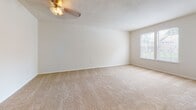 Located at 9274 Hanover Crossings Dr in Mechanicsville, Virginia, this single-floor unit offers a practical and comfortable layout with a neutral color palette throughout. The living area is generously sized, featuring plush wall-to-wall carpeting, a ceiling fan with light fixture, and a window that brings in natural light. Sliding glass doors open directly onto a private deck, providing outdoor views of surrounding greenery and easy indoor-outdoor access.

The kitchen is designed with functionality in mind, featuring dark wood cabinetry, granite-style countertops, and a full suite of black Whirlpool appliances including a refrigerator, electric range, and over-the-range microwave. A peninsula counter with a raised bar connects the kitchen to the living space, creating an open-concept feel. Wood-style flooring runs through the kitchen and extends into the bathroom.

The bedroom is a comfortable retreat with soft carpeting, a double closet with bifold doors offering ample storage, and direct access to additional areas of the unit. The bathroom includes a dark-cabinet vanity with a white countertop sink, a medicine cabinet mirror, and a full tub and shower combination, all finished with wood-style flooring for a cohesive look.