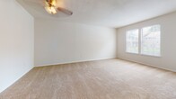 Located at 9274 Hanover Crossings Dr in Mechanicsville, Virginia, this single-floor unit offers a practical and comfortable layout with a neutral color palette throughout. The living area is generously sized, featuring plush wall-to-wall carpeting, a ceiling fan with light fixture, and a window that brings in natural light. Sliding glass doors open directly onto a private deck, providing outdoor views of surrounding greenery and easy indoor-outdoor access.

The kitchen is designed with functionality in mind, featuring dark wood cabinetry, granite-style countertops, and a full suite of black Whirlpool appliances including a refrigerator, electric range, and over-the-range microwave. A peninsula counter with a raised bar connects the kitchen to the living space, creating an open-concept feel. Wood-style flooring runs through the kitchen and extends into the bathroom.

The bedroom is a comfortable retreat with soft carpeting, a double closet with bifold doors offering ample storage, and direct access to additional areas of the unit. The bathroom includes a dark-cabinet vanity with a white countertop sink, a medicine cabinet mirror, and a full tub and shower combination, all finished with wood-style flooring for a cohesive look.