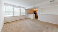 Located at 165 Kathann Dr in Hampton, Virginia, this single-floor residence offers a practical and comfortable layout designed for everyday living. The open living area is generously sized, featuring plush wall-to-wall carpeting and a bank of windows that allow abundant natural light to fill the space. It connects seamlessly to the kitchen via a peninsula-style counter, making the layout ideal for both relaxing and entertaining. The kitchen is well-equipped with warm wood cabinetry, dark granite-style countertops, tile flooring, and a full suite of stainless steel appliances including a refrigerator, electric range, and built-in microwave. The bedrooms continue the carpeted aesthetic, offering clean, neutral walls and natural light through windows with blinds. The bathroom features tile flooring, a full tub-shower combination with chrome fixtures, and a clean, simple finish. A dedicated in-unit laundry area with a stacked washer and dryer adds significant convenience. Throughout the residence, the design is practical and cohesive, with consistent neutral tones, tile in wet areas, and carpet in living and sleeping spaces, creating a comfortable and move-in ready environment.