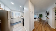 Located at 2550 E Riverside Dr in Ontario, CA, this thoughtfully designed single-floor home offers two bedrooms and two bathrooms across a comfortable, efficiently arranged layout. Warm wood-look flooring flows through the entryway, hallway, and living areas, creating a cohesive and inviting atmosphere throughout.

The open living room is bright and airy, featuring clean white walls that complement the neutral palette. A welcoming hallway leads from the entry into the main living space, with a dedicated closet providing convenient storage.

The kitchen is outfitted with white cabinetry, a gas range, stainless steel refrigerator, and a wall-mounted range hood. Recessed lighting and a window above the sink bring natural light into the space, keeping the kitchen feel open and functional.

The primary bedroom features plush carpet flooring, soft neutral tones, and sliding glass doors that open to an outdoor area, allowing natural light to fill the room. The bathrooms are finished with light wood-look flooring, white vanities, and a clean, minimalist aesthetic.

Throughout the home, the design emphasizes a light, modern sensibility with consistent finishes, making it a comfortable and practical living space in the heart of Ontario's Riverside Drive corridor.