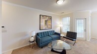 This single-floor, two-bedroom, two-bathroom residence is thoughtfully designed to maximize functionality and comfort. The living area features crown molding, carpet flooring, and natural light from windows fitted with blinds. A tufted sofa, glass coffee table, and modern artwork contribute to a clean, contemporary ambiance.

The dining area benefits from multiple windows offering outdoor views, and is anchored by a pendant light fixture with brushed nickel finishes. Adjacent to the dining space, the kitchen is equipped with stainless steel appliances, including a range, microwave, and refrigerator, complemented by dark granite-style countertops and warm wood cabinetry.

A notable built-in desk nook with granite-style countertop and a floating shelf provides a dedicated workspace. The primary bedroom includes a ceiling fan, carpet flooring, and closet access, while the secondary bedroom offers a comfortable, well-lit retreat with a window. Both bathrooms feature vanities with wood cabinetry; one includes a tub/shower combo, and the other offers a stand-up shower, with hardwood-style flooring adding a refined touch.