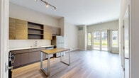 This thoughtfully designed 2-bedroom, 1-bathroom residence at 150 Glover Ave in Norwalk, CT offers a clean, contemporary aesthetic throughout its well-proportioned single-floor layout. Light hardwood flooring runs continuously through all rooms, creating a cohesive and airy feel. The open-concept kitchen is a standout feature, outfitted with stainless steel appliances including a gas range, microwave, dishwasher, and refrigerator. Warm wood-grain cabinetry with open shelving is complemented by light countertops and a central kitchen island with a butcher block top, ideal for dining or meal prep. The living area benefits from soaring ceilings and large glass doors that invite abundant natural light and outdoor views. The generously sized primary bedroom offers ample space, with high ceilings and a window framing views of the surrounding neighborhood. The second bedroom is equally well-lit, featuring dual windows with neighborhood views. The bathroom is finished with a long dual-sink vanity, sleek grey cabinetry, white countertops, a large mirror with overhead lighting, and a walk-in shower. Neutral wall tones throughout enhance the bright, modern ambiance of this well-appointed Norwalk residence.
