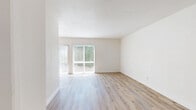 Located in the Reseda neighborhood of Los Angeles, this one-bedroom, one-bathroom unit offers a bright and clean living environment across a single floor. The open-plan kitchen and living area form the heart of the home, where natural light pours in through large windows dressed with vertical blinds. A ceiling fan overhead adds both function and a touch of character to the living space, which flows seamlessly from the kitchen.

The kitchen is well-appointed with ample white shaker-style cabinetry, light stone countertops, a stainless steel sink, and a stainless steel gas range with an overhead vent hood. The layout is efficiently designed to maximize counter and storage space.

Light wood-look flooring runs consistently throughout the entire unit, contributing to a cohesive and modern aesthetic. Crisp white walls and white baseboards enhance the sense of brightness and cleanliness in every room.

The bedroom is a comfortable, well-proportioned space with a window providing natural light and easy access to an adjacent closet area. The bathroom features white cabinetry with a light countertop and a separate water closet, maintaining the unit's clean and minimal design language. Overall, the space presents a fresh, move-in ready interior with a light and airy ambiance.