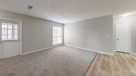 Located at 3600 Park Lake Ln in Peachtree Corners, GA, this single-floor, 2-bedroom, 2-bathroom home offers a well-designed layout with a neutral color palette and a blend of hard-surface and carpeted flooring throughout. The galley-style kitchen is a standout feature, showcasing white shaker cabinets, dark granite countertops, a mosaic tile backsplash, and stainless steel appliances, including a refrigerator, range, and dishwasher. Light wood-look floors run through the kitchen and main living areas, while an adjacent dining room provides a dedicated space for meals. The spacious living room features plush carpet, textured ceilings, and a large window with blinds that invites natural light. Both bedrooms are generously sized with soft carpeting, windows, and ample closet access — the primary suite connects directly to a bathroom with a full tub-shower combination. The second bathroom features a white vanity with shaker-style cabinetry and a large mirror. Five closets distributed throughout the home offer exceptional storage capacity. An in-unit laundry area and a utility room add everyday convenience, while a private balcony extends the living space outdoors. The overall ambiance is clean, functional, and move-in ready.