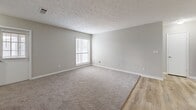 Located at 3600 Park Lake Ln in Peachtree Corners, GA, this single-floor, 2-bedroom, 2-bathroom home offers a well-designed layout with a neutral color palette and a blend of hard-surface and carpeted flooring throughout. The galley-style kitchen is a standout feature, showcasing white shaker cabinets, dark granite countertops, a mosaic tile backsplash, and stainless steel appliances, including a refrigerator, range, and dishwasher. Light wood-look floors run through the kitchen and main living areas, while an adjacent dining room provides a dedicated space for meals. The spacious living room features plush carpet, textured ceilings, and a large window with blinds that invites natural light. Both bedrooms are generously sized with soft carpeting, windows, and ample closet access — the primary suite connects directly to a bathroom with a full tub-shower combination. The second bathroom features a white vanity with shaker-style cabinetry and a large mirror. Five closets distributed throughout the home offer exceptional storage capacity. An in-unit laundry area and a utility room add everyday convenience, while a private balcony extends the living space outdoors. The overall ambiance is clean, functional, and move-in ready.