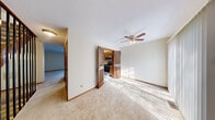 Located in Columbus, Ohio, this two-story home offers a practical and well-organized layout across two floors. The main level features a carpeted living room with a ceiling fan and a pass-through window connecting to the kitchen, creating an open, communicative flow between spaces. The kitchen is accessible through charming louvered bi-fold doors and is equipped with stainless steel appliances—including a refrigerator, dishwasher, and range—set against warm wood cabinetry, a tile backsplash, and light-toned flooring. A notable feature on the main level is a sliding glass door that fills the space with natural light and provides outdoor access.

Both bedrooms are carpeted and bright, each featuring ceiling fans and sliding glass doors that let in generous natural light. The spacious primary bedroom boasts two separate closets with wood-paneled doors, offering ample storage. The two bathrooms are finished with grey tile wainscoting and wood-look flooring. One bathroom features a granite countertop vanity, while the other includes a full bathtub and shower with brushed nickel fixtures. Throughout the home, warm wood trim and neutral tones create a cohesive, comfortable ambiance suited for everyday living.