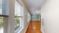 Located on Park Terrace in Hartford, CT, this 2-bedroom, 1-bathroom residence offers a comfortable and well-organized single-floor layout. Rich hardwood flooring flows consistently throughout the living areas, hallway, and bedrooms, lending warmth and continuity to the space.

The entry hallway is lined with a series of large windows fitted with blinds, inviting generous natural light and views of surrounding greenery. This corridor leads into an open living room with neutral walls and multiple windows that brighten the space.

The kitchen is well-equipped with rich wood cabinetry, granite countertops, stainless steel appliances including a range, dishwasher, and refrigerator, and a tile floor. A window above the sink provides additional light and ventilation.

The primary bedroom is a comfortable, well-lit room featuring soft blue-green walls, polished hardwood floors, and windows overlooking an outdoor balcony area. The second bedroom mirrors this calming aesthetic with similar tones and ample natural light from a trio of windows. Both rooms benefit from access to multiple closets — five closets total throughout the unit offer excellent storage.

The bathroom features a full tub-shower combination with white tile surround, a wood vanity with granite countertop, and a medicine cabinet. The unit's clean finishes and thoughtful design make it a highly functional and inviting residence.