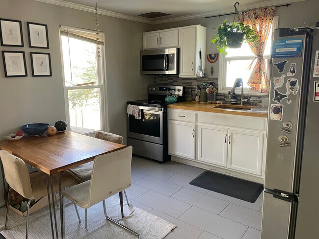 Updated kitchen with white cabinetry, ample counter space, and natural light. - 520 Commonwealth St