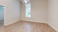 Located at 462 Cherry Street in Macon, GA, this one-bedroom, one-bathroom unit offers a well-designed single-floor layout with modern finishes throughout. The open-concept kitchen and living area serves as the heart of the home, featuring soaring ceilings with recessed lighting, a peninsula breakfast bar, and light wood-style flooring that extends throughout the entire unit. The kitchen is outfitted with gray shaker-style cabinetry, granite countertops, and a full suite of stainless steel appliances including a refrigerator with ice maker, range, built-in microwave, and dishwasher. The bedroom is a comfortable, well-proportioned room with a ceiling fan, natural light from a window with blinds, and neutral-toned walls. The bathroom includes a vanity with granite countertop and gray cabinetry, a tub/shower combo with tile surround, and wood-style flooring. A dedicated laundry room with a full-size washer and dryer adds everyday convenience. The unit's clean, neutral palette and consistent flooring create a cohesive and move-in-ready living environment.