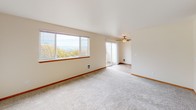 Located at 4620 South 254th Place in Kent, Washington, this single-floor home offers a well-organized layout designed for comfortable living. The living room is a standout space, featuring large windows that frame sweeping outdoor views of the surrounding landscape and lush trees, flooding the room with natural light. A ceiling fan adds a practical touch, while a sliding glass door provides access to an outdoor area. Soft carpeting extends throughout the main living and bedroom areas, contributing to a warm and inviting ambiance. The kitchen is efficiently designed with warm wood cabinetry offering generous storage, laminate countertops, a double-basin sink, and white appliances including a coil-top range and refrigerator. Tile flooring and overhead lighting keep the space functional and easy to maintain. The bedrooms are carpeted and well-proportioned, with one featuring a wide reach-in closet with built-in rod storage, and another offering a low-profile window that lets in natural light. The bathroom is clean and straightforward, equipped with a tub-shower combination, toilet, vanity with a granite-style countertop, and tile flooring. Overall, this home presents a practical and comfortable living environment in a scenic Kent location.