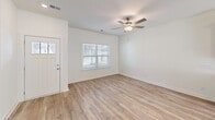 Located at 3164 Mulberry Blvd in Port Wentworth, Georgia, this two-story home offers a well-designed layout spread across two floors. The main level features an open-concept kitchen and living area finished with light hardwood-style flooring and ceiling fans throughout. The kitchen is a standout, boasting white shaker cabinetry, a subway tile backsplash, granite countertops, stainless steel appliances, and a central island with a built-in sink, pendant lighting, and bar seating. A sliding glass door brings in abundant natural light and provides outdoor access. The living area is bright and welcoming, with a front entry door and large windows fitted with blinds. The bathrooms are finished with granite-topped white vanities, brushed nickel hardware, and tub-shower combinations. A dedicated laundry room houses a full-size washer and dryer with overhead shelving for added storage. Upstairs, the two bedrooms are carpeted and feature ceiling fans and windows that allow natural light. The generously sized primary bedroom offers a comfortable retreat. The exterior presents classic siding construction with a small yard, completing this functional and modern home.