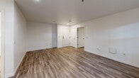 Located at 1323 SW Cherry Park Rd in Troutdale, Oregon, this well-appointed one-bedroom, one-bathroom unit offers a thoughtfully designed single-floor layout. Throughout the space, durable wood-look flooring ties the rooms together with a warm, cohesive aesthetic set against crisp white walls and clean white trim.

The open living and dining area is bright and inviting, featuring a wide window that draws in natural light and offers views of the surrounding greenery. A wall-mounted HVAC unit ensures year-round comfort. The space flows naturally into the kitchen, which is separated by a half-wall pass-through. The kitchen is well-equipped with light maple cabinetry, ample counter space, a stainless steel refrigerator, and a stainless steel electric range with an overhead ventilation hood.

The bedroom is a comfortable, private retreat with its own window providing natural light, recessed lighting overhead, and direct access to two closets — one of which is a spacious walk-in with wire shelving for organized storage. The bathroom features a glass-door shower enclosure and is conveniently accessible from the hallway. The unit also benefits from two closets, providing generous storage throughout. This clean, move-in-ready unit offers practical, comfortable living in a serene Troutdale setting.